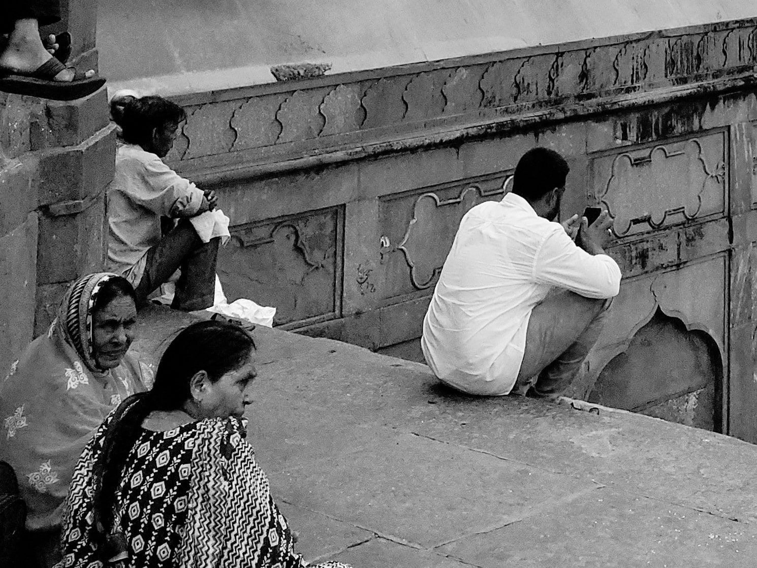 Black and white photo of people resting on old stone steps