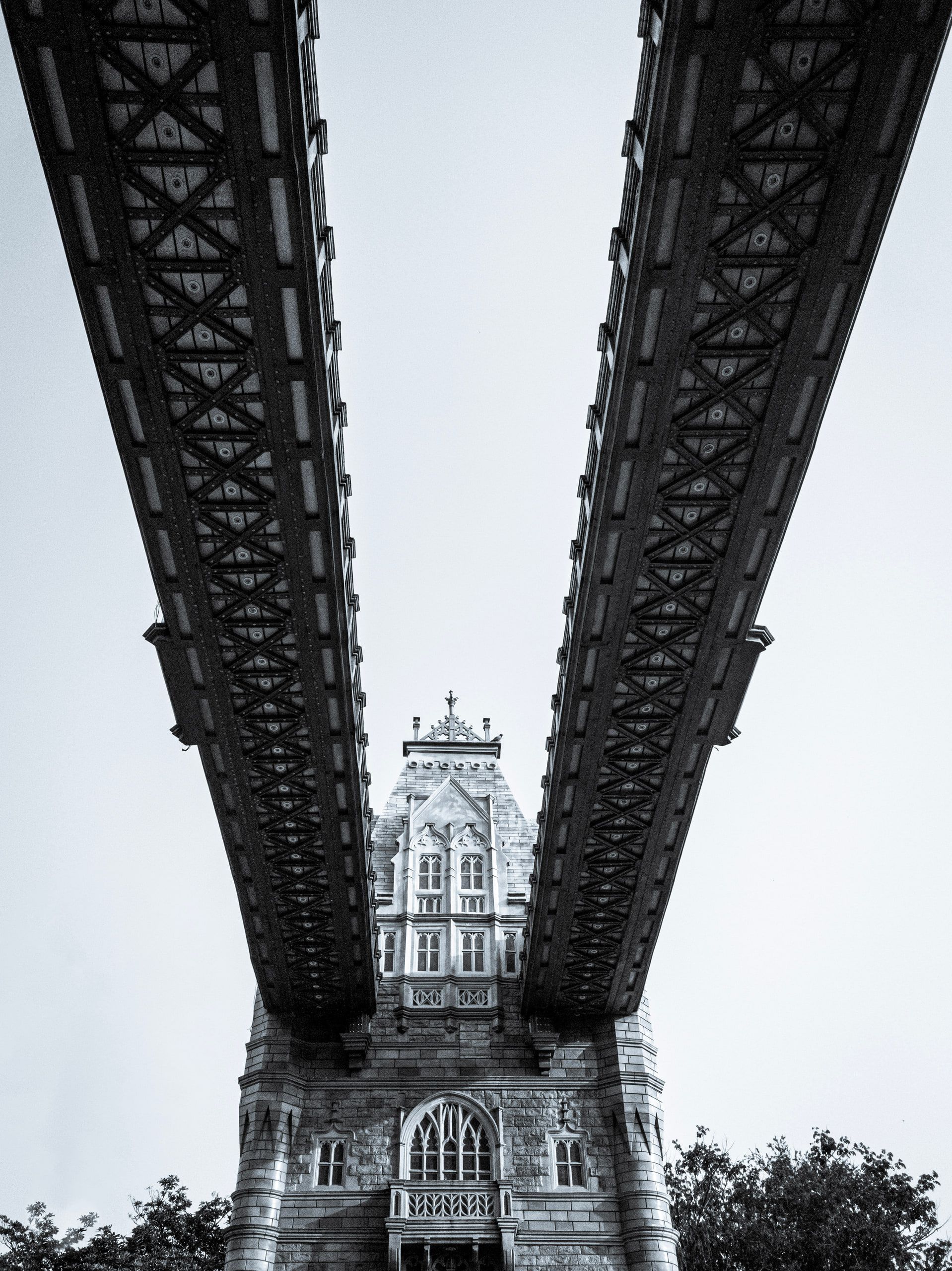 Looking up between two steel bridge girders at a gothic tower