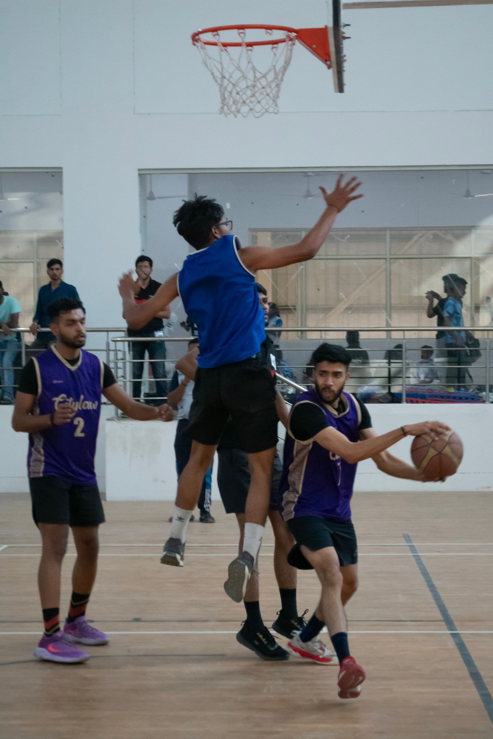 Basketball players contesting a shot under the hoop