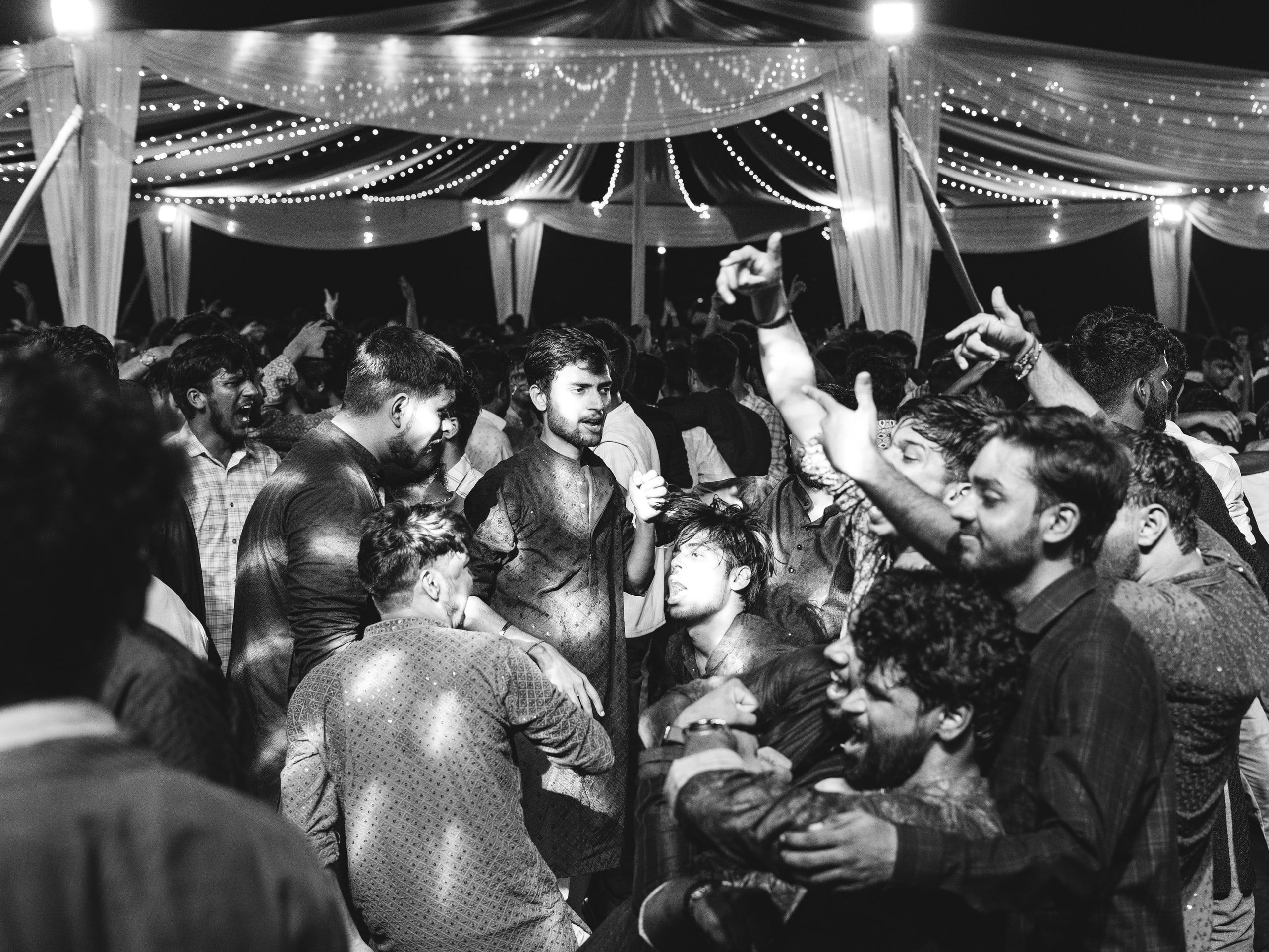A packed dance floor under a lit canopy