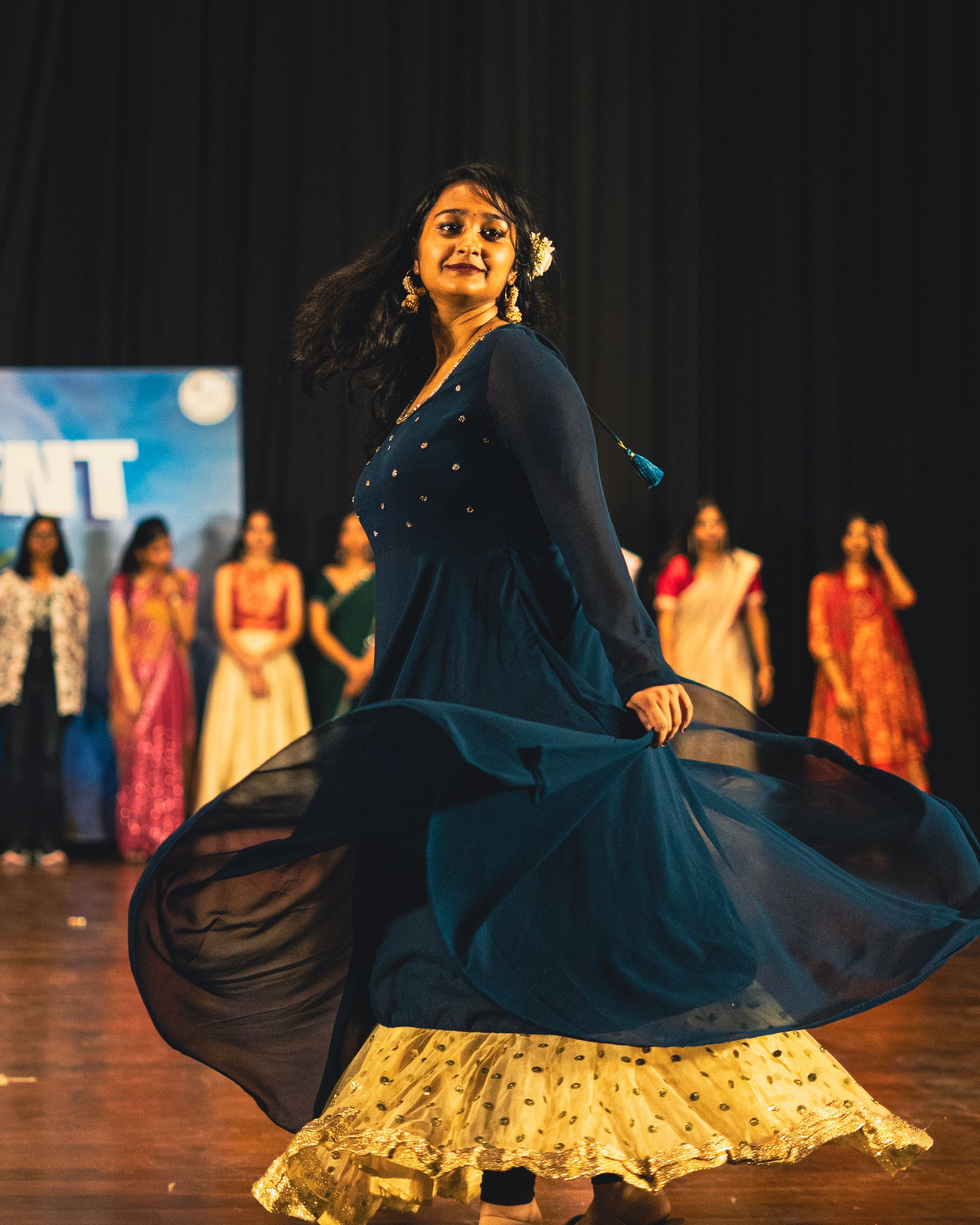 A dancer in a flowing blue dress spinning on stage