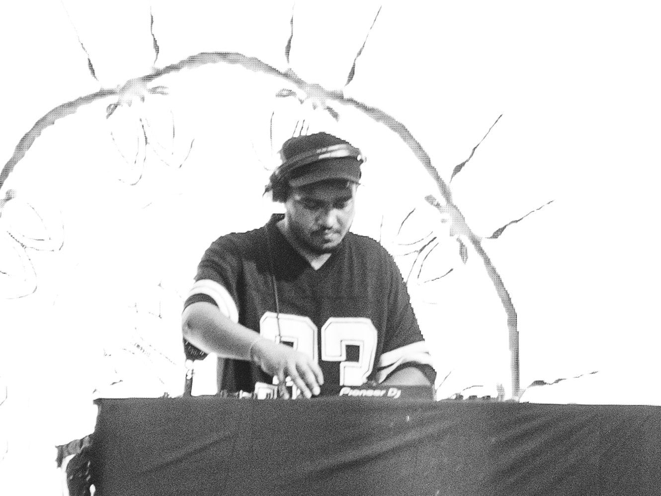 High-key black and white photo of a DJ at the decks