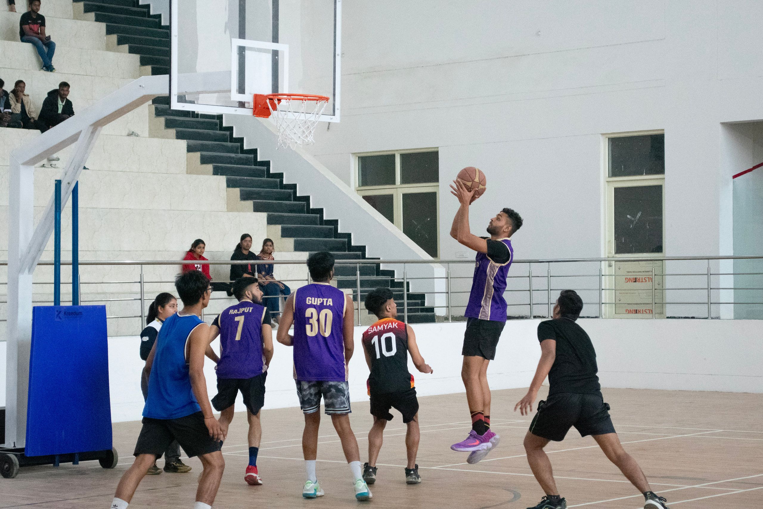 A basketball player driving to the hoop on an indoor court