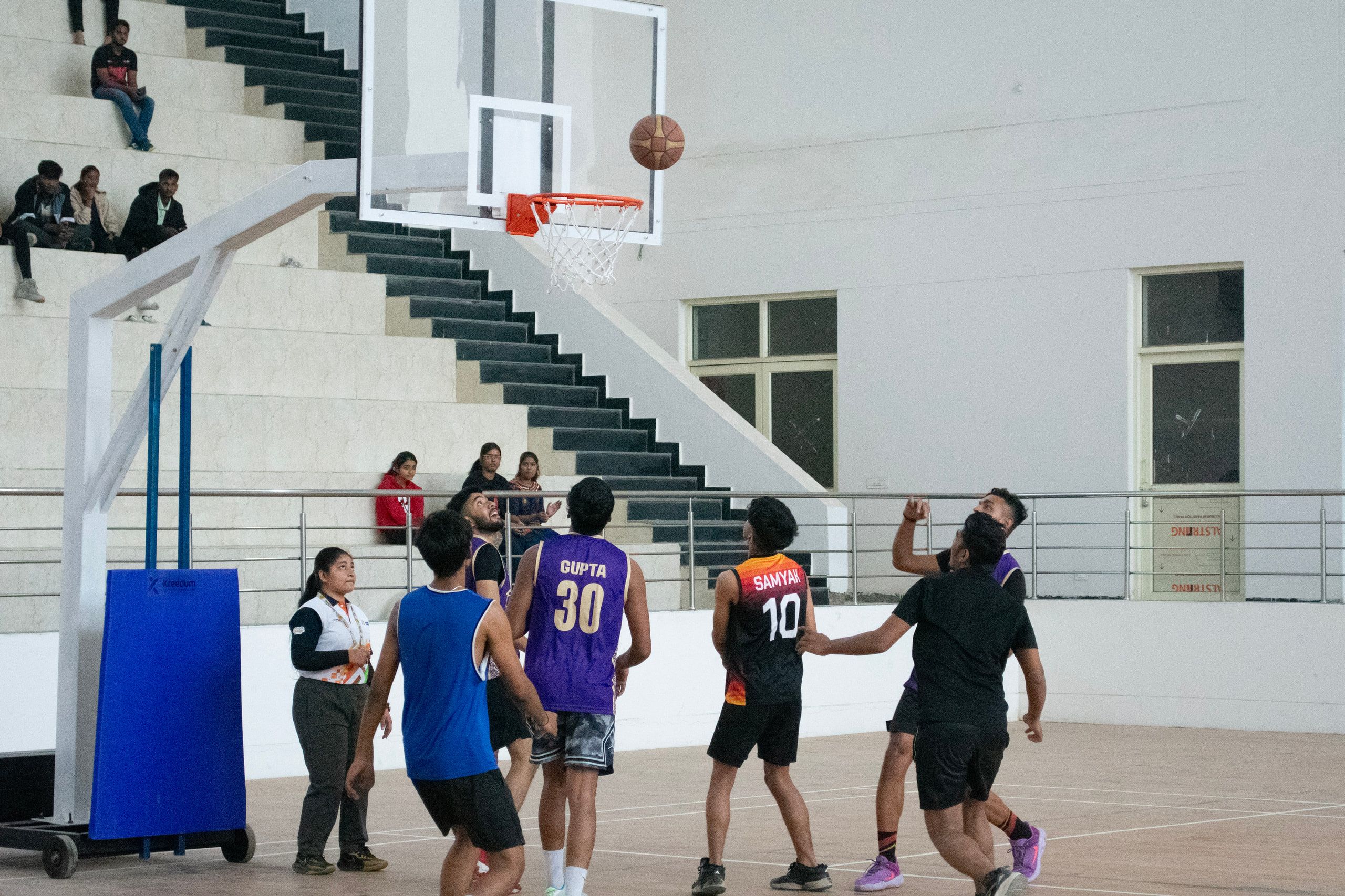 Basketball players racing up an indoor court