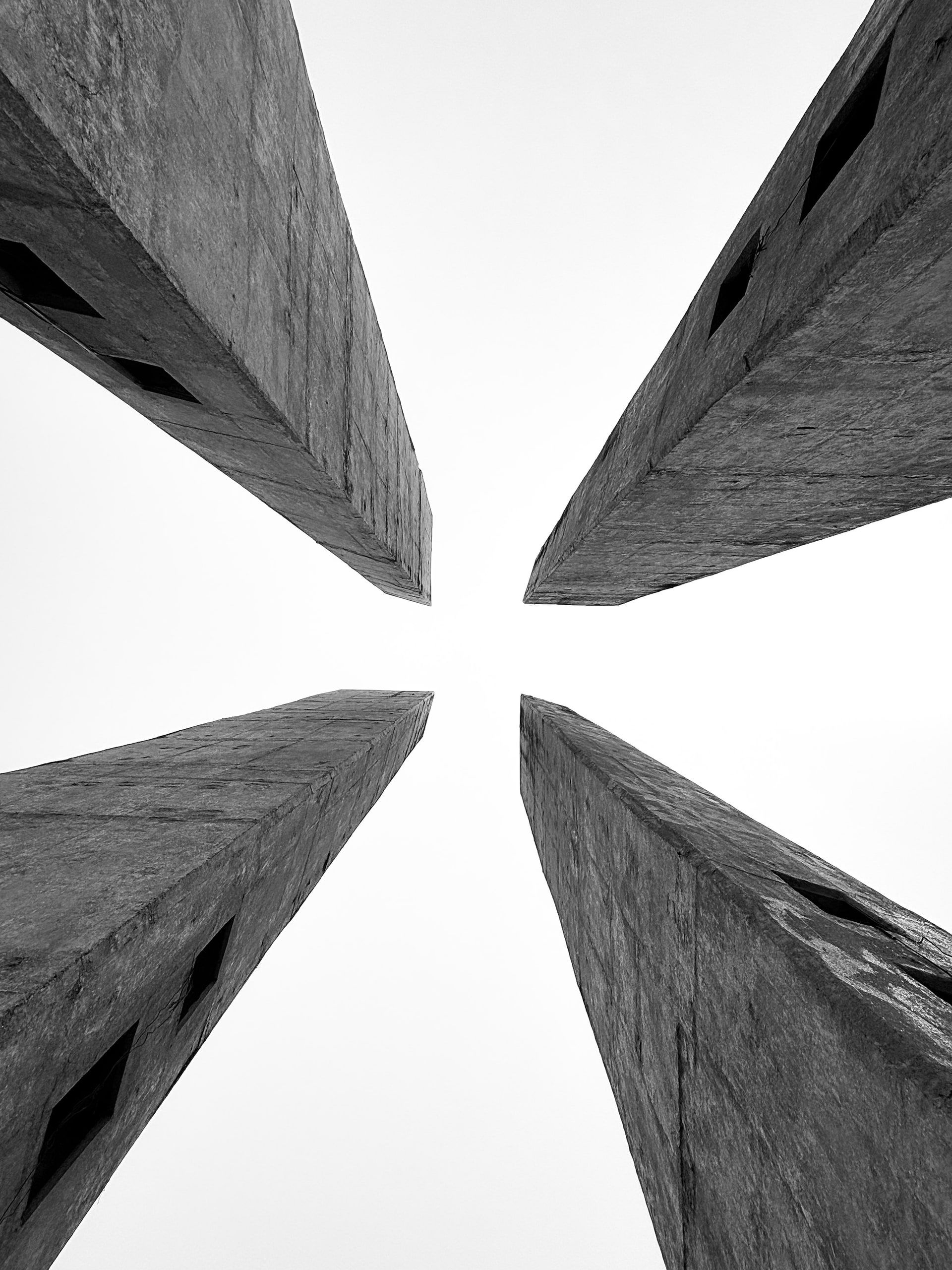Black and white view looking straight up between four buildings