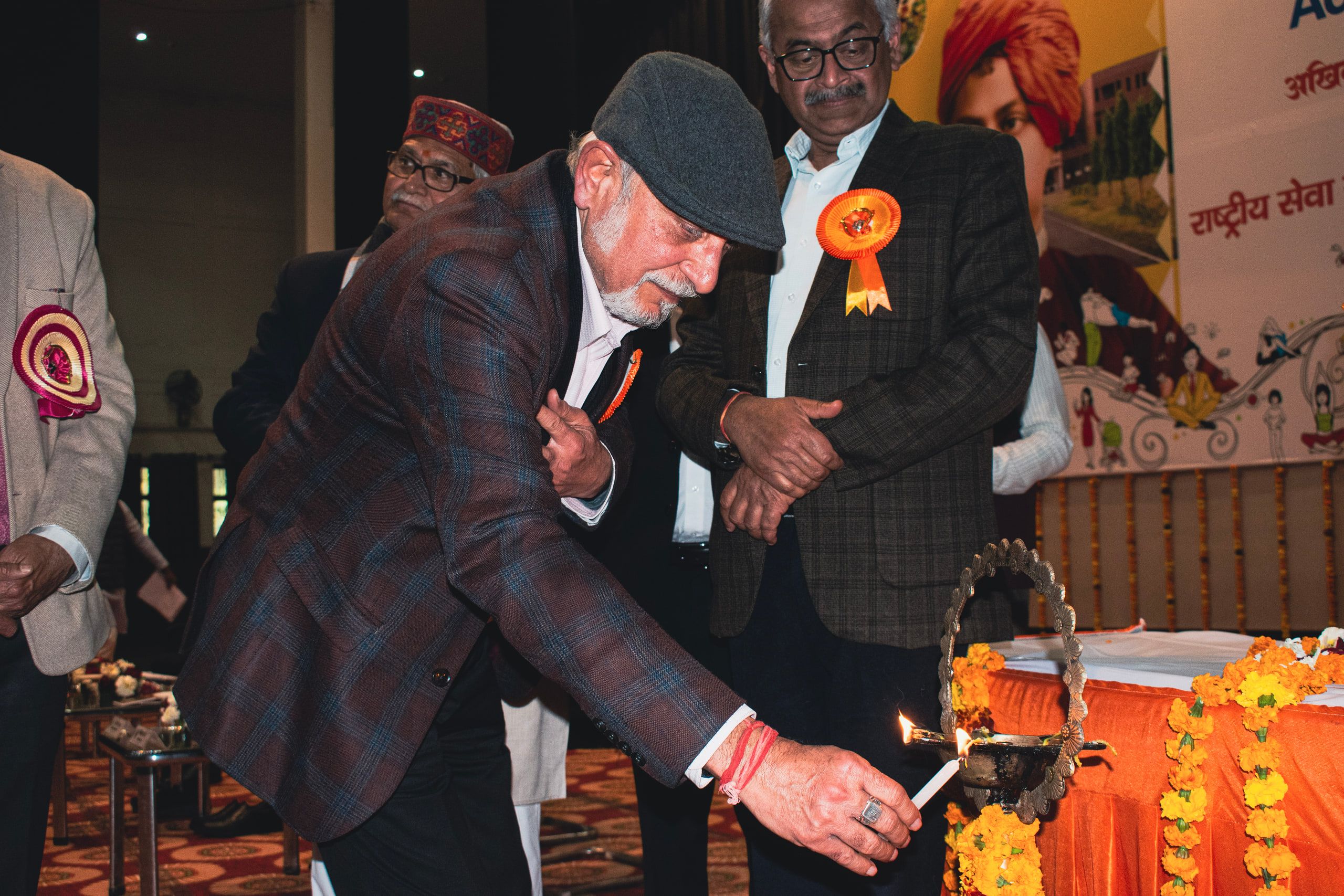 An elderly guest lighting a ceremonial lamp