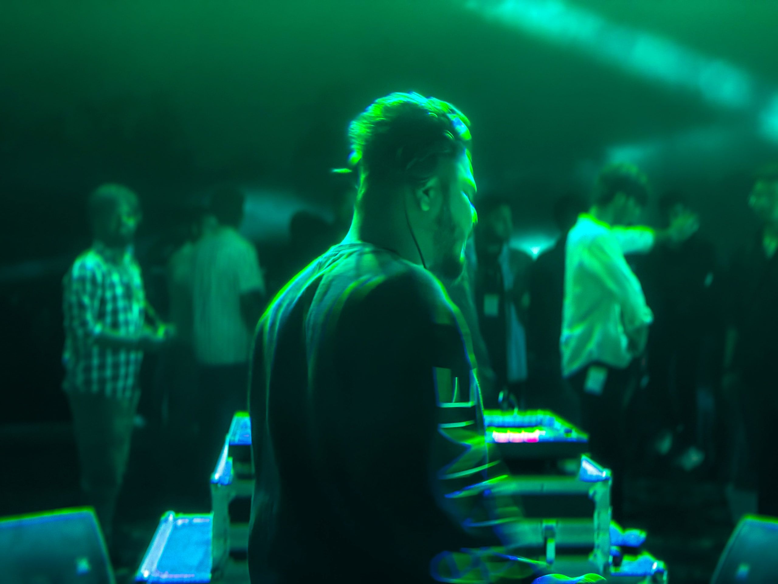 A DJ at the decks washed in green light