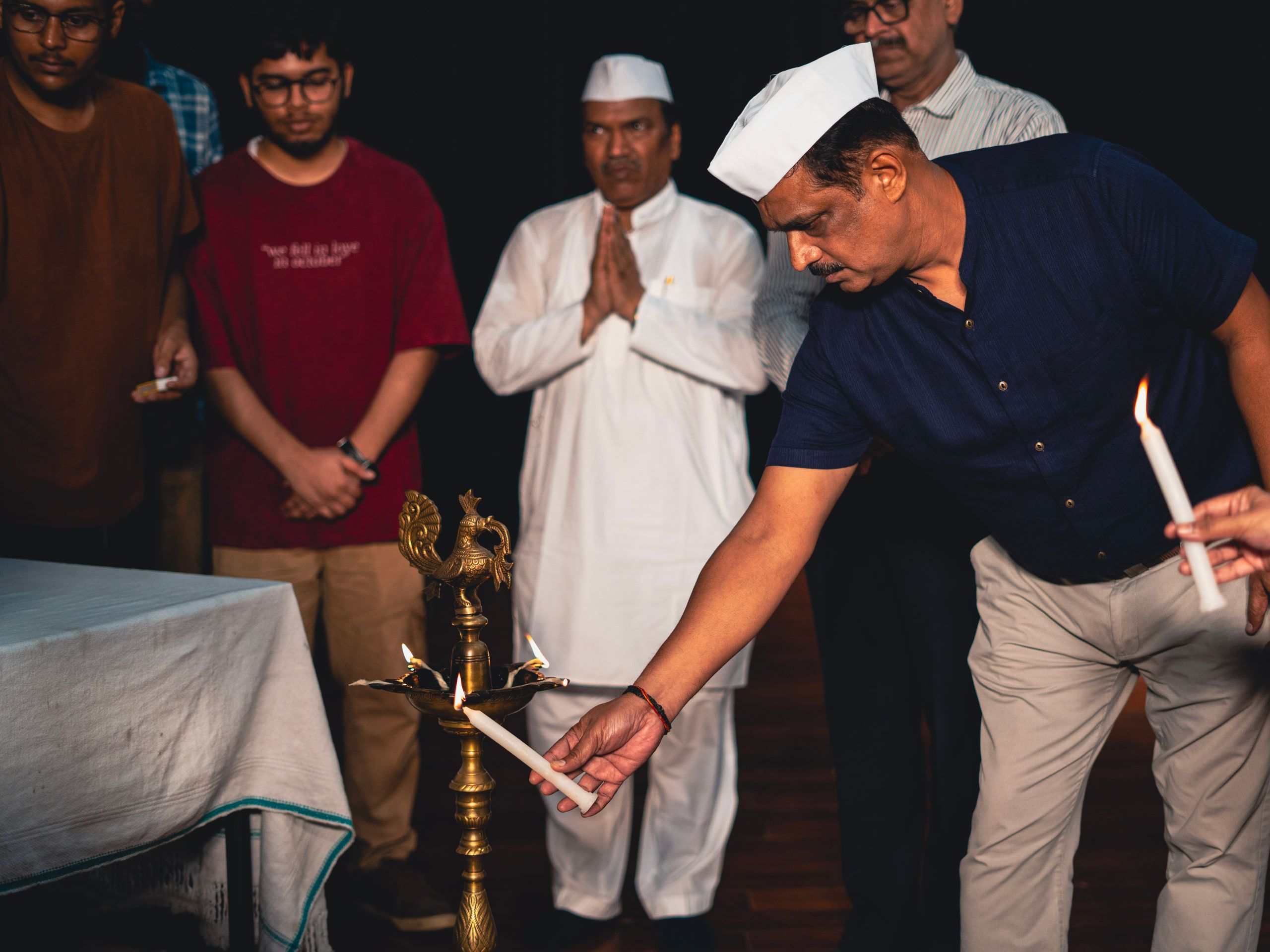 Guests lighting candles at a ceremonial lamp