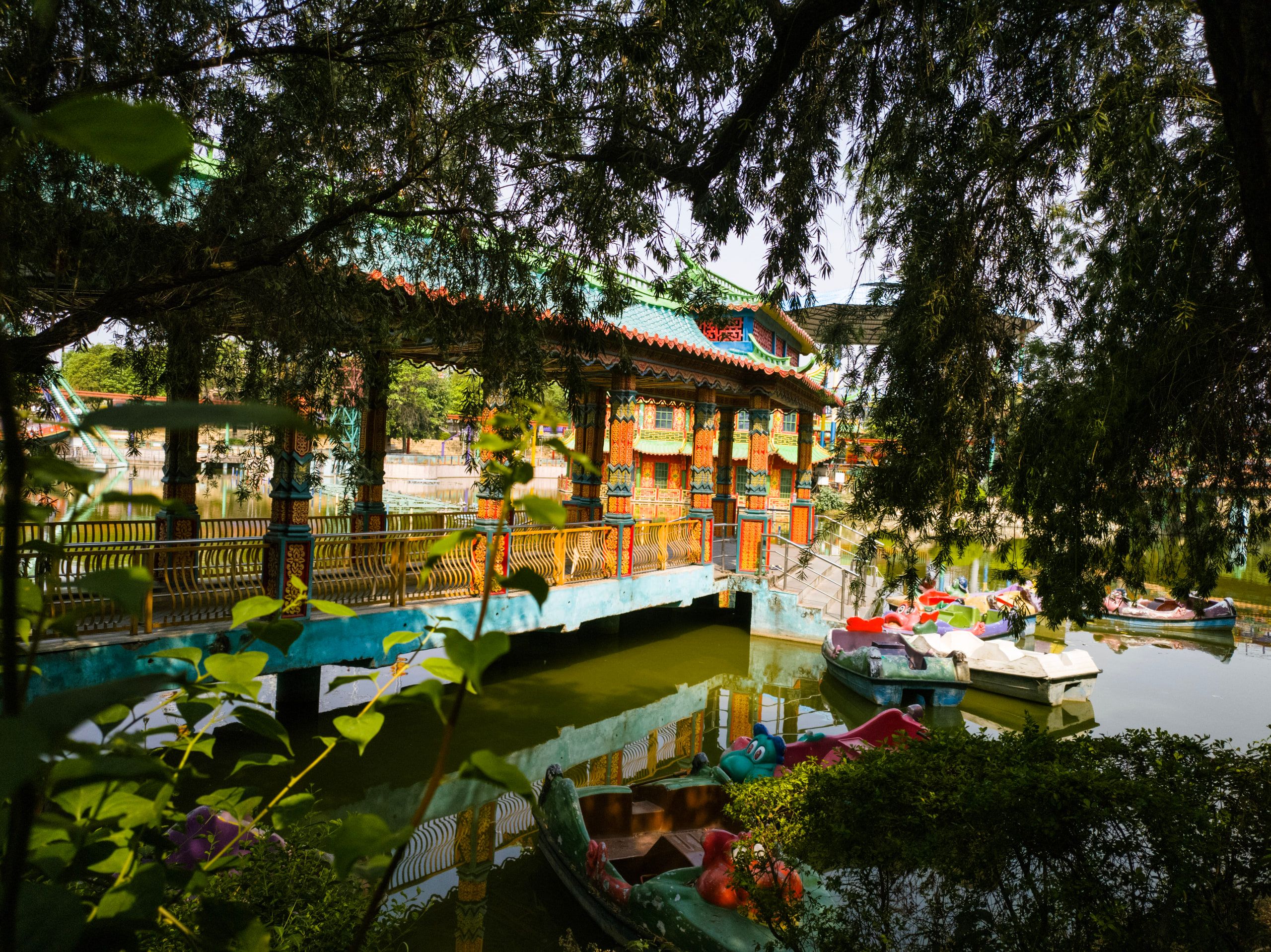 A pavilion and boats on a lake framed by trees