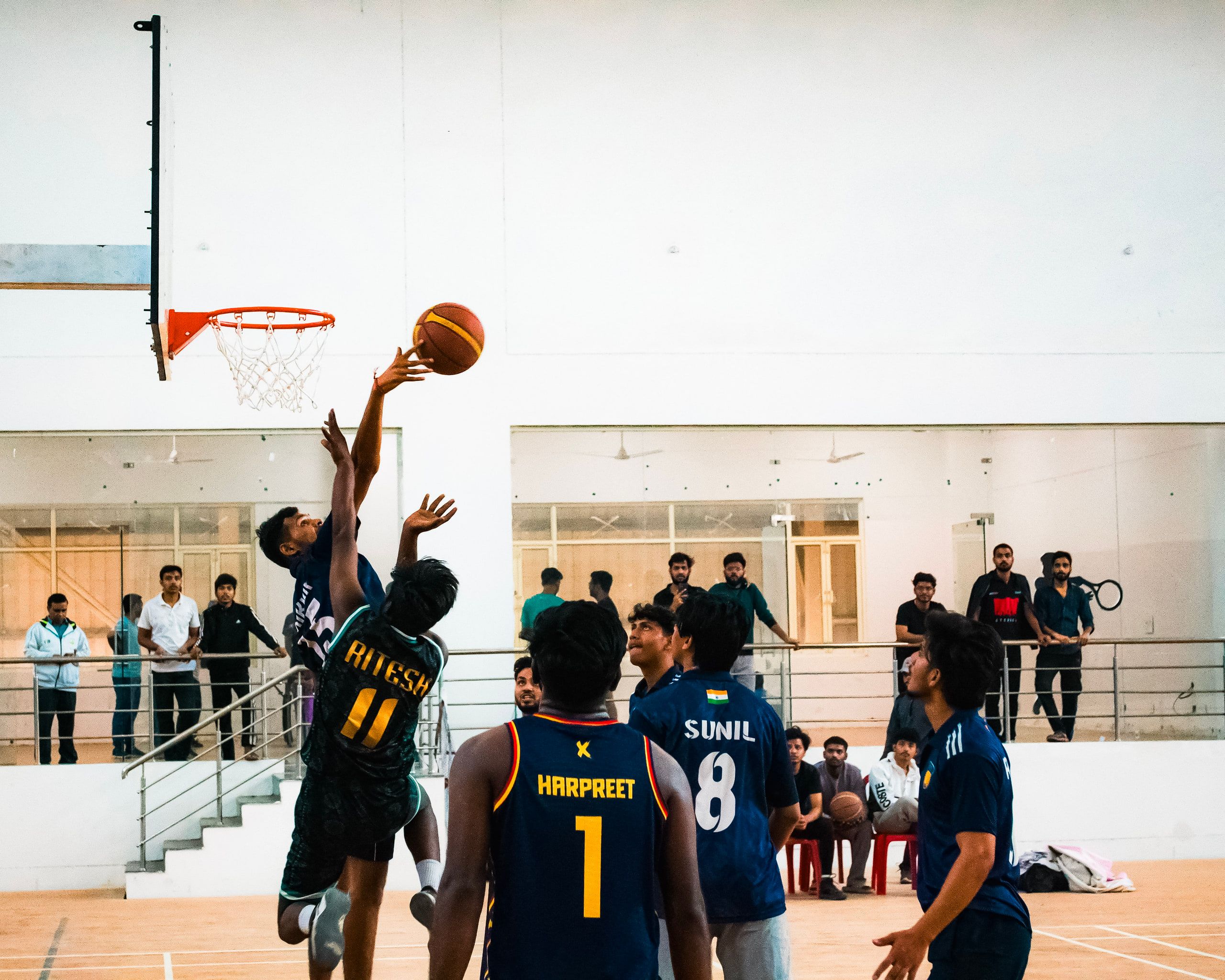 A basketball player going up for a layup as defenders watch