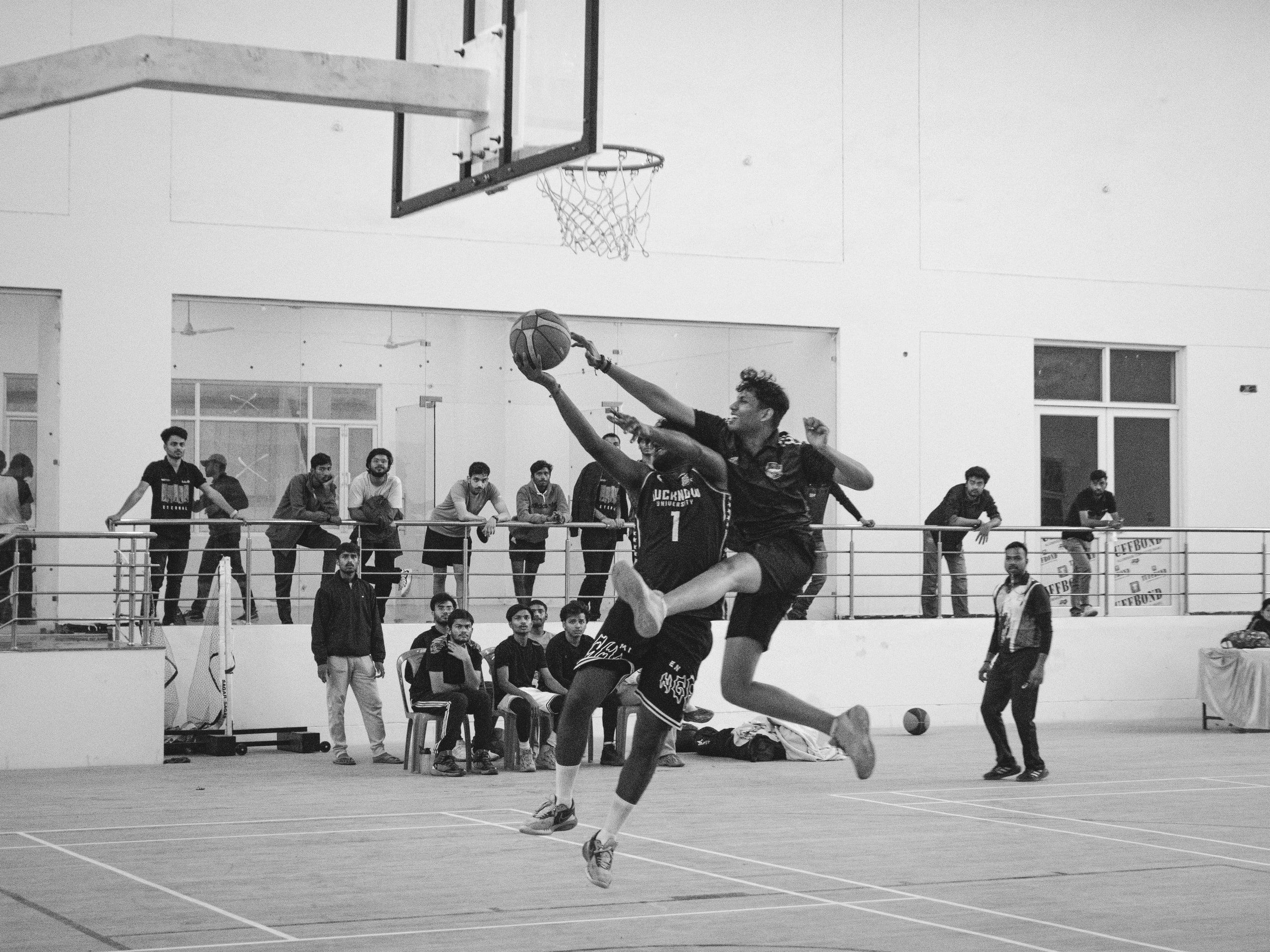 Black and white shot of basketball players in mid-air