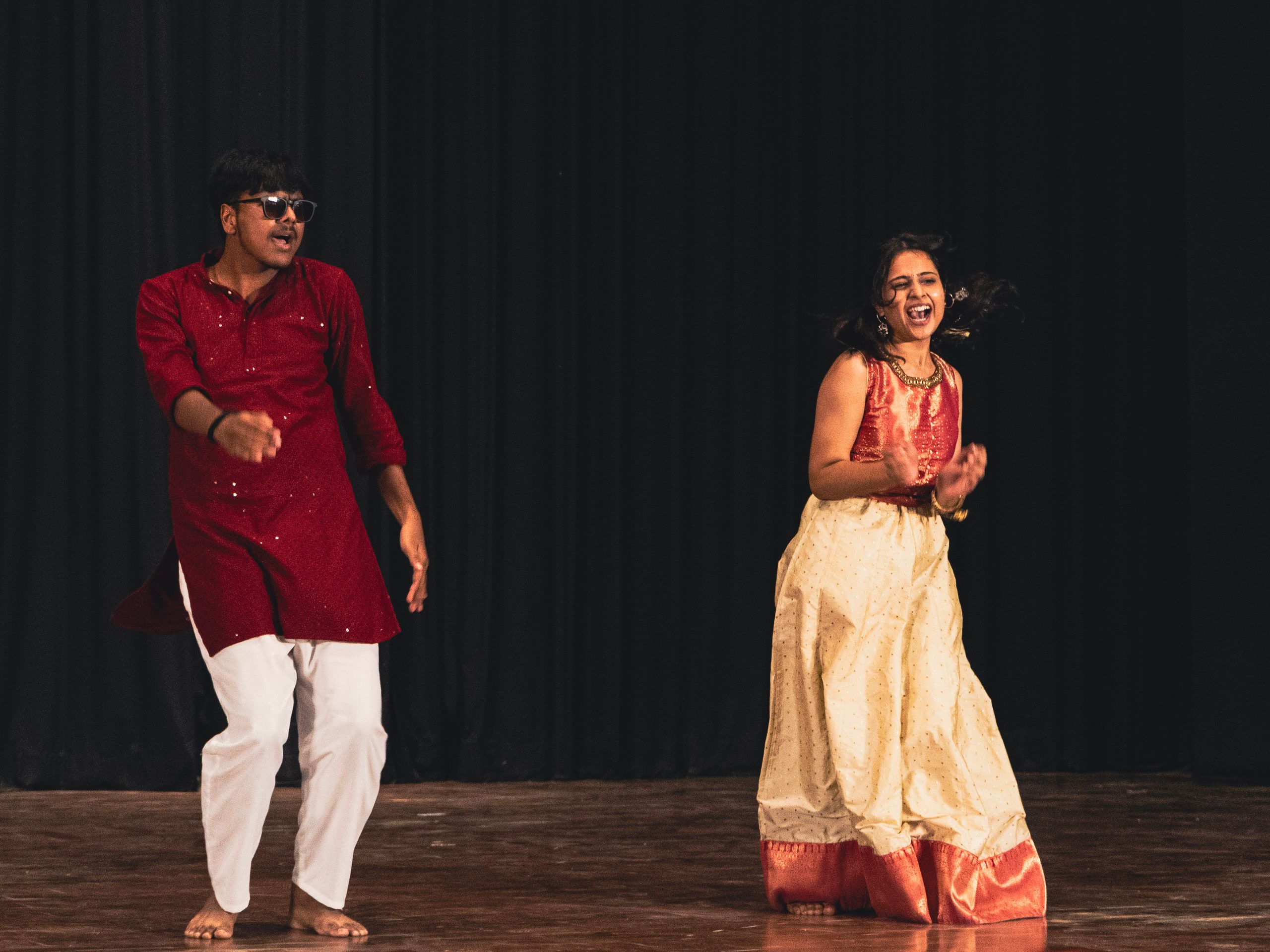 Two dancers in traditional dress performing on stage