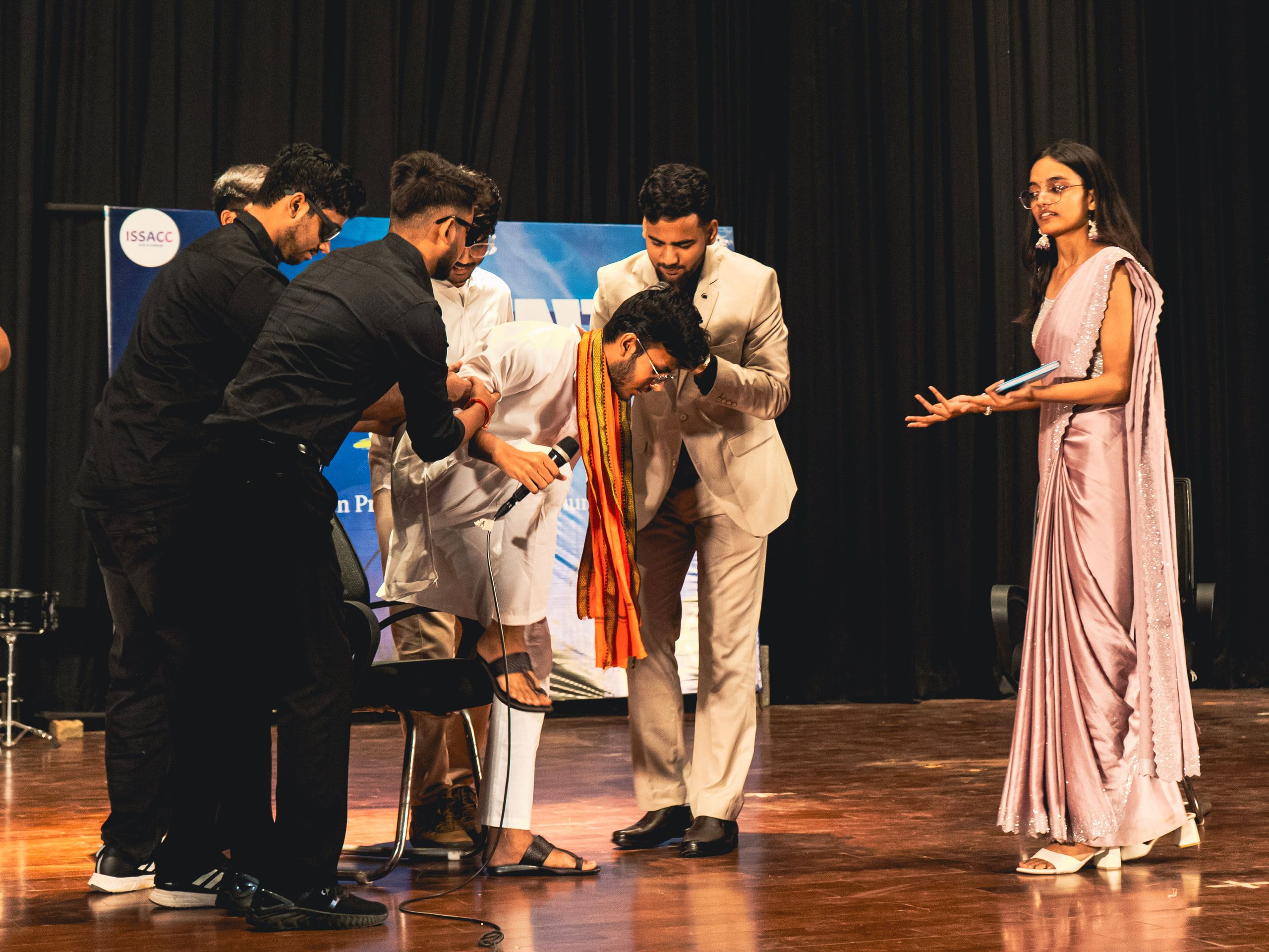 Actors in costume performing a scene on stage